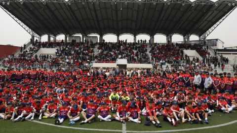 Cientos de niños y niñas posan para una foto durante la inauguración de una nueva escuela del Atlético Madrid en Cuenca, Ecuador, el jueves 14 de noviembre de 2024.