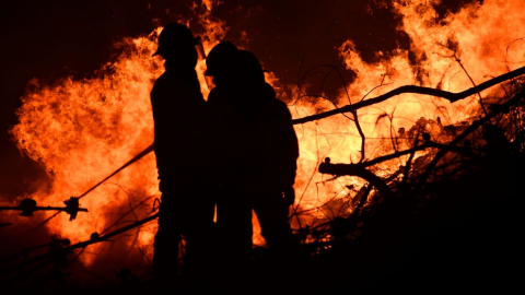 bomberos en medio de un incendio forestal en Loja