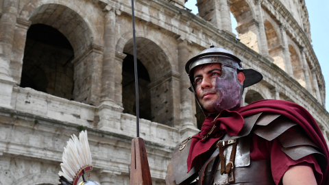 Un hombre vestido con un traje de centurión romano participa en un desfile histórico para celebrar el cumpleaños de Roma frente al Coliseo de Roma.