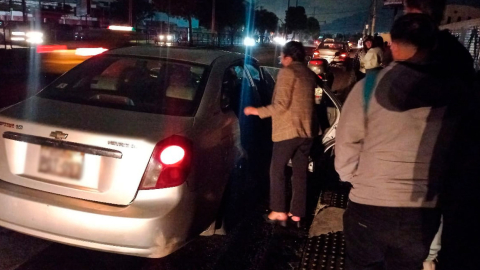 Ciudadana aborda un vehículo en Quito en medio de calles sin luz por los apagones.