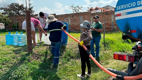 Ciudadanos reciben agua potable con un tanquero en Quito.