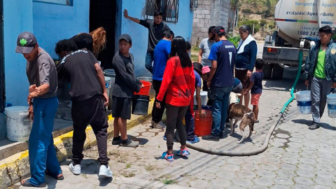 Moradores sin agua en Quito reciben el líquido vital con un tanquero.