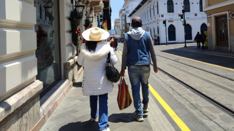 Ciudadanos se protegen de la intensa radiación solar en Cuenca.