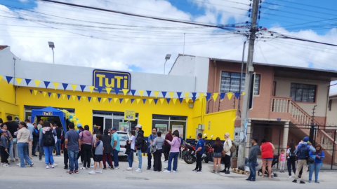 Personas hacen fila en los exteriores de una tienda Tuti en Cuenca