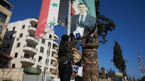 Milicianos sirios 'rebeldes' rompen un retrato del presidente de Siria, Bashar al-Assad, en el centro de Alepo, el 30 de noviembre de 2024.