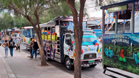 'Chivas' estacionadas en una calle de Quito mientras esperan para salir.