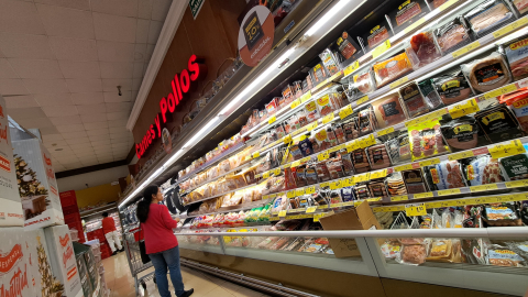 Una mujer mira las opciones de carnes y pollos en un supermercado en el norte de Quito, el 4 de diciembre de 2024.