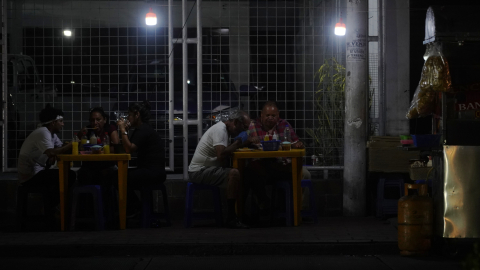 Un negocio de comidas informal en Guayaquil atiende con focos recargables, en un sector del norte de la ciudad, el viernes 6 de diciembre de 2024.