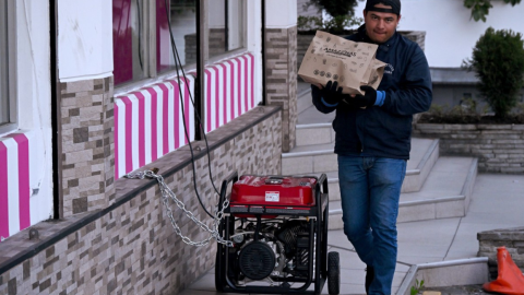 Un hombre camina junto a un generador eléctrico