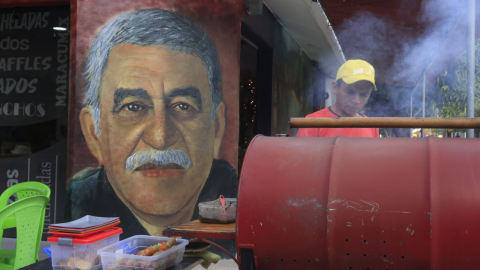 Un hombre cocina frente a un mural con la imagen del escritor Gabriel García Márquez, 11 de diciembre 2024.