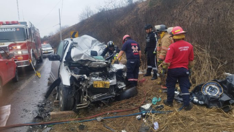 Personal de emergencia trabaja en un vehículo accidentado en la vía Manta-Crucita, en el cantón Portoviejo, cerca del puente El Duende, el 13 de diciembre de 2024.