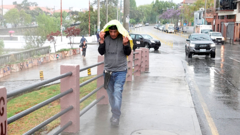 Imagen de archivo de un hombre que se cubre de la lluvia en Cuenca.