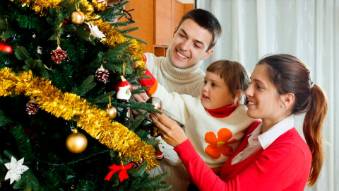 Imagen referencial de una familia junto a un árbol de Navidad.