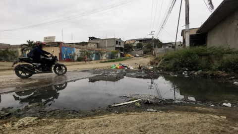 Acumulación de aguas servidas y de basura en la bajada de un cerro de la cooperativa San Francisco, en el norte de Guayaquil, el 29 de noviembre de 2024. El sector carece de alcantarillado sanitario desde hace 25 años y deberá esperar por el servicio hasta 2028.