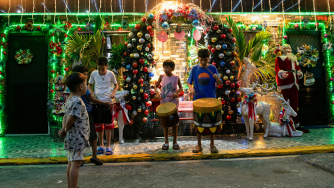 Los niños practican villancicos frente a una casa decorada, 12 de diciembre de 2024.