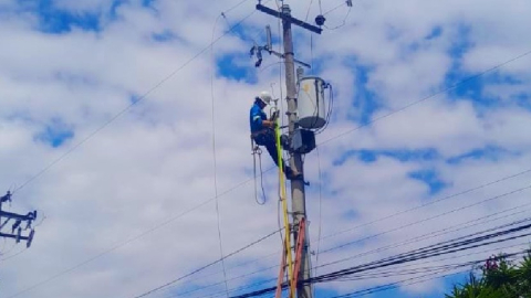 Trabajador de la Empresa Eléctrica Quito realiza reparaciones en un poste de Sangolquí, el 22 de diciembre de 2024.