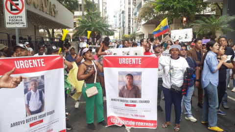 Ciudadanos sostienen carteles con imágenes de los niños desaparecidos en Guayaquil durante el plantón que se lleva a cabo el 23 de diciembre de 2024.