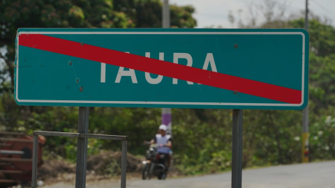 Un letrero con una línea roja para situaciones de peligro señaliza la salida sur de la parroquia rural de Taura (Naranjal, Guayas), el 24 de diciembre de 2024. Se trata del último paradero conocido de cuatro menores desaparecidos y donde se hallaron cuatro cuerpos incinerados.