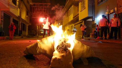 Fotografía de archivo que muestra un año viejo de aserrín siendo consumido por el fuego mientras se recibe un nuevo año en Cuenca, Ecuador.