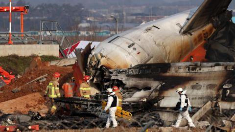 Integrantes del cuerpo del bomberos trabaja en los restos del avión de Jeju Air en el aeropuerto internacional de Muan el 29 de diciembre de 2024, al suroeste de Seúl, Corea del Sur.