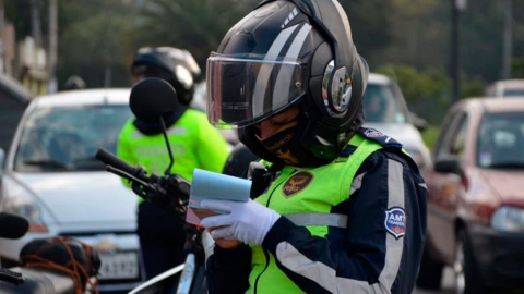 Agente de tránsito de Quito emite una multa en una vía de la capital.