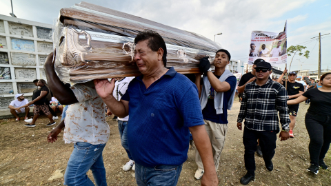 Un hombre llora mientras carga a hombros el féretro de uno de los cuatro niños de Las Malvinas asesinados tras un operativo militar, durante el sepelio de los menores en el cementerio Ángel María Canals del Suburbio de Guayaquil, la tarde del 1 de enero de 2025.