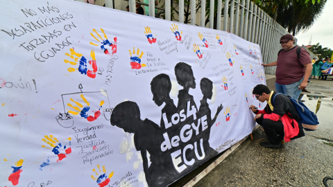 Manifestantes escriben en una pancarta durante una manifestación contra la desaparición de cuatro menores que desaparecieron en una operación militar, frente al Complejo Judicial Valdivia, al sur de Guayaquil, el 31 de diciembre de 2024.