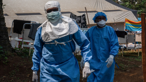 Dos trabajadores de la ONG Alima caminan por el patio del centro de tratamiento de mpox en Kamituga, 20 de septiembre de 2024.