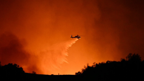 Un helicóptero arroja agua en una zona incendiada de Encino, vecina de Los Ángeles, el 10 de enero de2025.