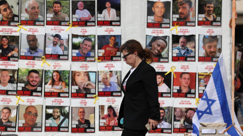 Una mujer camina en enero de 2025 frente a un grupo de afiches con los que se exige la liberación de rehenes israelíes, retenidos tras ataques de Hamás a Israel en octubre de 2023.