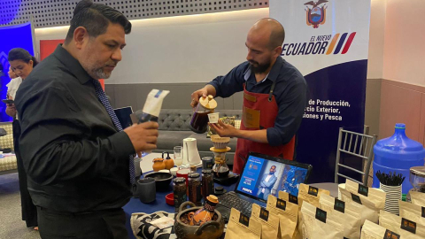 Un emprendedor ofrece café a un visita en una feria de pymes en Machala, en julio de 2024.