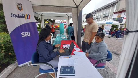 Una funcionaria del SRI ofrece información sobre servicios tributarios a una ciudadana en el parque principal de Atuntaqui, en la provincia de Imbabura, 16 de enero de 2025.