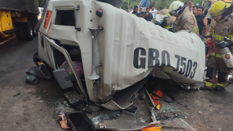 Bomberos revisan la carrocería de un tráiler accidentado en la vía a la Costa, en Guayas.