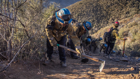 Los bomberos trabajan para crear una línea de contención contra incendios para controlar el incendio Hughes en Castaic, 23 de enero de 2025.