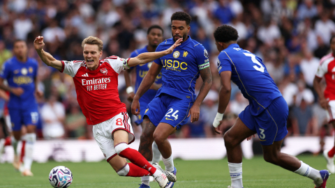 Martin Odegaard (i), jugador del Arsenal, cae ante la marca de futbolistas del Chelsea, el domingo 6 de septiembre, por la Premier League.