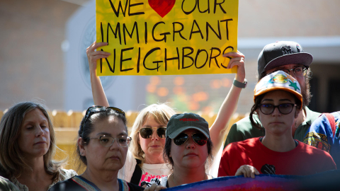 Una mujer sostiene un cartel este 21 de septiembre de 2026, en el lugar donde un inmigrante venezolano recibió un disparo por la espalda de un agente del ICE el pasado domingo en Austin, Estados Unidos.