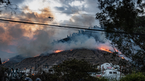 Un helicóptero realiza descargas aéreas de agua durante un incendio forestal en el cerro Casitagua, en Quito, el 17 de septiembre de 2026.