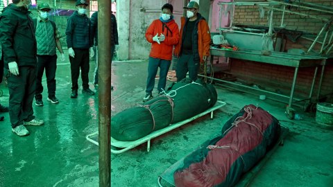 Amigos y familiares reaccionan a la llegada de los cuerpos de dos víctimas de una avalancha al Hospital Universitario Tribhuvan de Katmandú, Nepal, el 28 de septiembre de 2026.