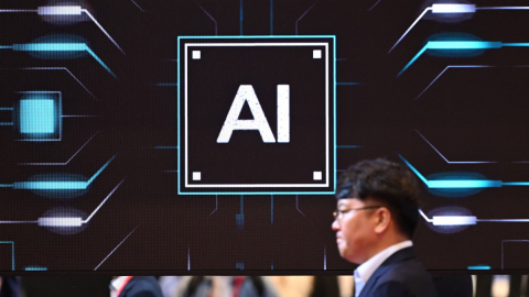 Un hombre camina delante de una imagen sobre Inteligencia Artificial durante una exhibición sobre semiconductores, en el centro de convenciones COEX, en Seúl, el 14 de octubre de 2026.