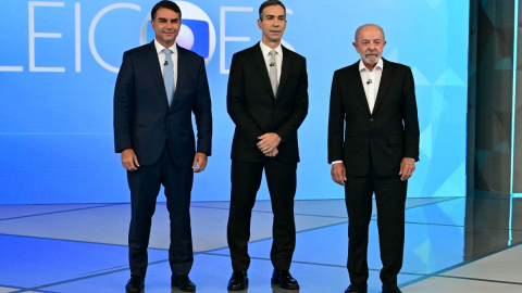 El candidato presidencial derechista brasileño Flavio Bolsonaro, el periodista y moderador del debate Cesar Tralli, y el presidente de Brasil y candidato presidencial Luiz Inácio Lula da Silva posan antes de un debate presidencial previo a la segunda vuelta electoral en Río de Janeiro, Brasil, el 23 de octubre de 2026