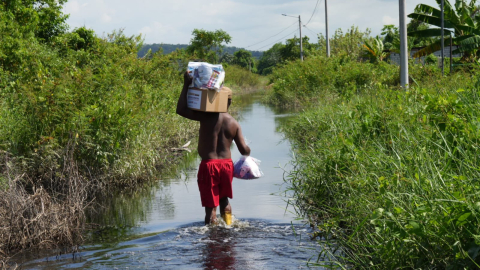 Una persona atraviesa una vía inundada mientras transporta provisiones en Muisne, Esmeraldas, en una fotografía difundida por la Secretaría Nacional de Gestión de Riesgos el 6 de octubre de 2026.