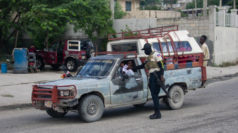 Un policía haitiano revisa los documentos de un conductor el sábado 24 de octubre de 2026, mientras continúa la búsqueda de cuatro militares salvadoreños integrantes de la Fuerza de Supresión de Pandillas desaparecidos tras sufrir una emboscada, en Puerto Príncipe (Haití).