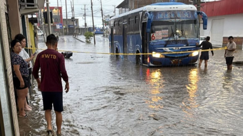 Un bus circula por una calle inundada en el barrio Costa Azul, de Manta, tras la intensa lluvia del 26 de octubre de 2026.