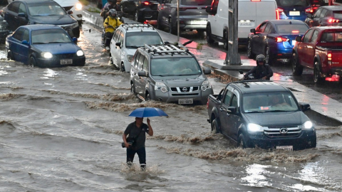 Un hombre camina por aguas anegadas tras fuertes lluvias en el norte de Guayaquil, Ecuador, el 26 de octubre de 2026.