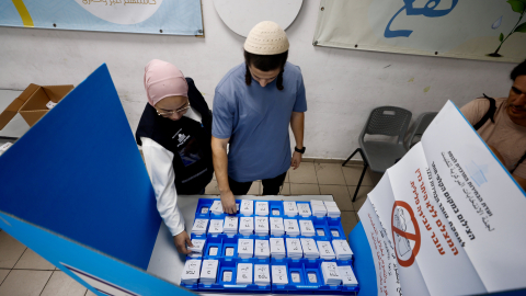 Dos personas eligen las papeletas para votar en un colegio electoral en Umm al-Fahm, Israel, el 27 de octubre de 2026.