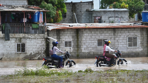 Motociclistas circulan en inundaciones persistentes por hasta cinco días en Machala (El Oro), el 28 de octubre del 2026, en medio de una tregua entre bandas criminales forzada por el clima.