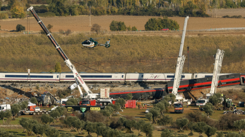 Un helicóptero de la Guardia Civil sobrevuela este 29 de octubre de 2026 la zona mientras los equipos de emergencia emplean grúas de gran tonelaje para retirar los vagones siniestrados en Toledo, España.