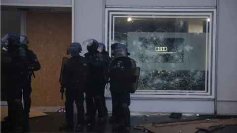 Policías antidisturbios frente a un edificio con una ventana rota durante una manifestación en Francia, en octubre de 2026.