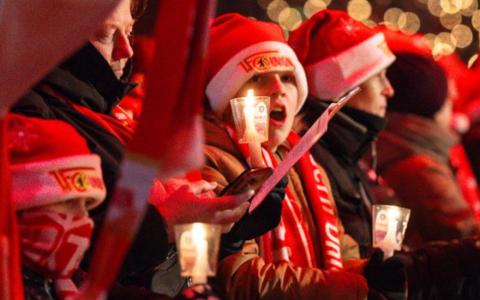 Un hincha del FC Unión Berlín canta villancicos con otros aficionados del club.