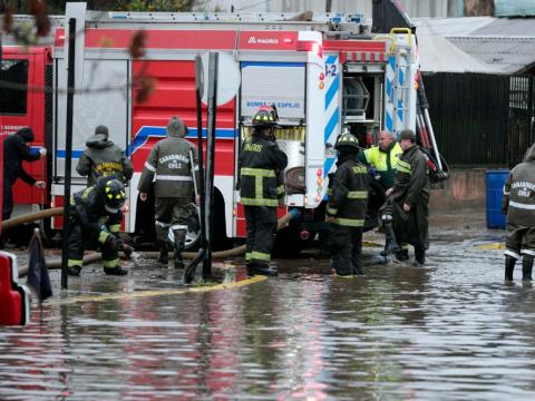 Carabineros y bomberos trabajan en calles inundadas por la lluvia en Santiago de Chile, el 13 de junio de 2024.